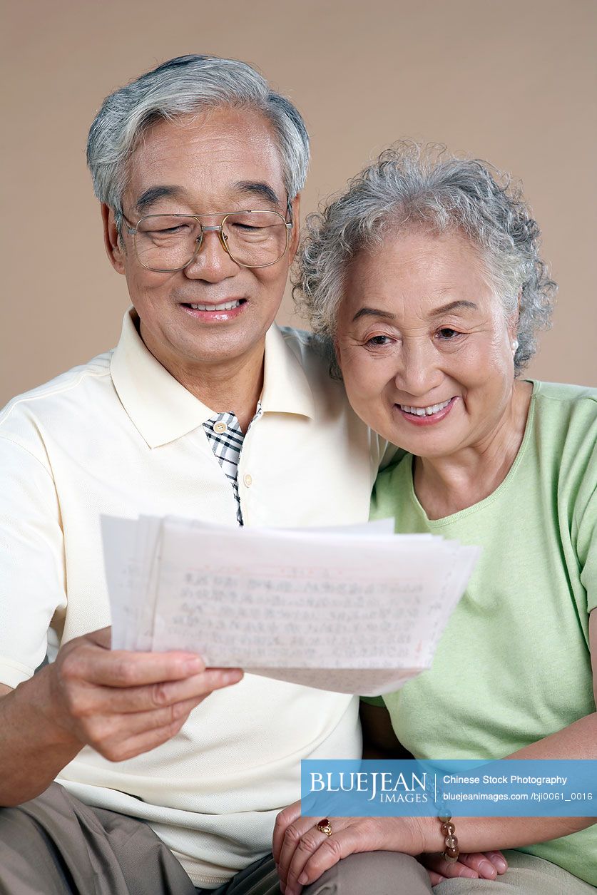 Elderly Chinese Couple Reading A Letter Together