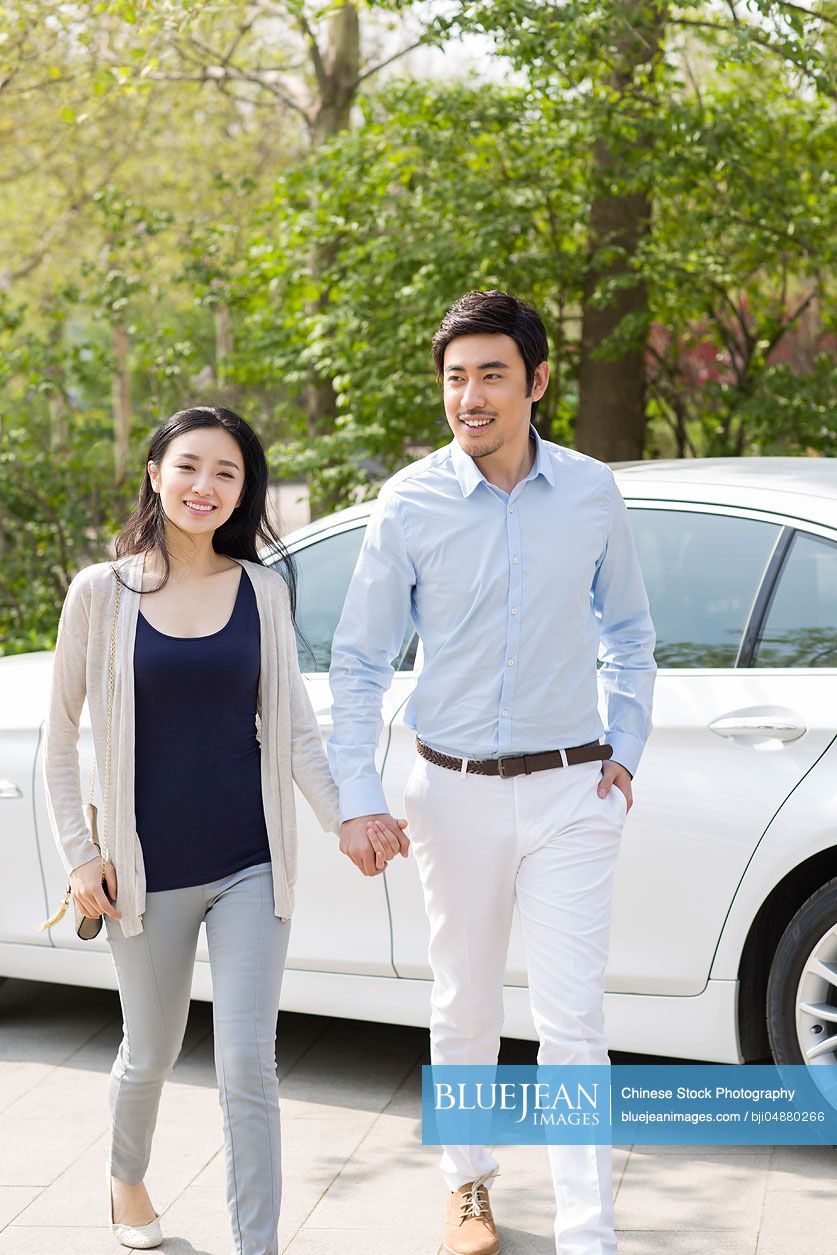 Happy young Chinese couple and car