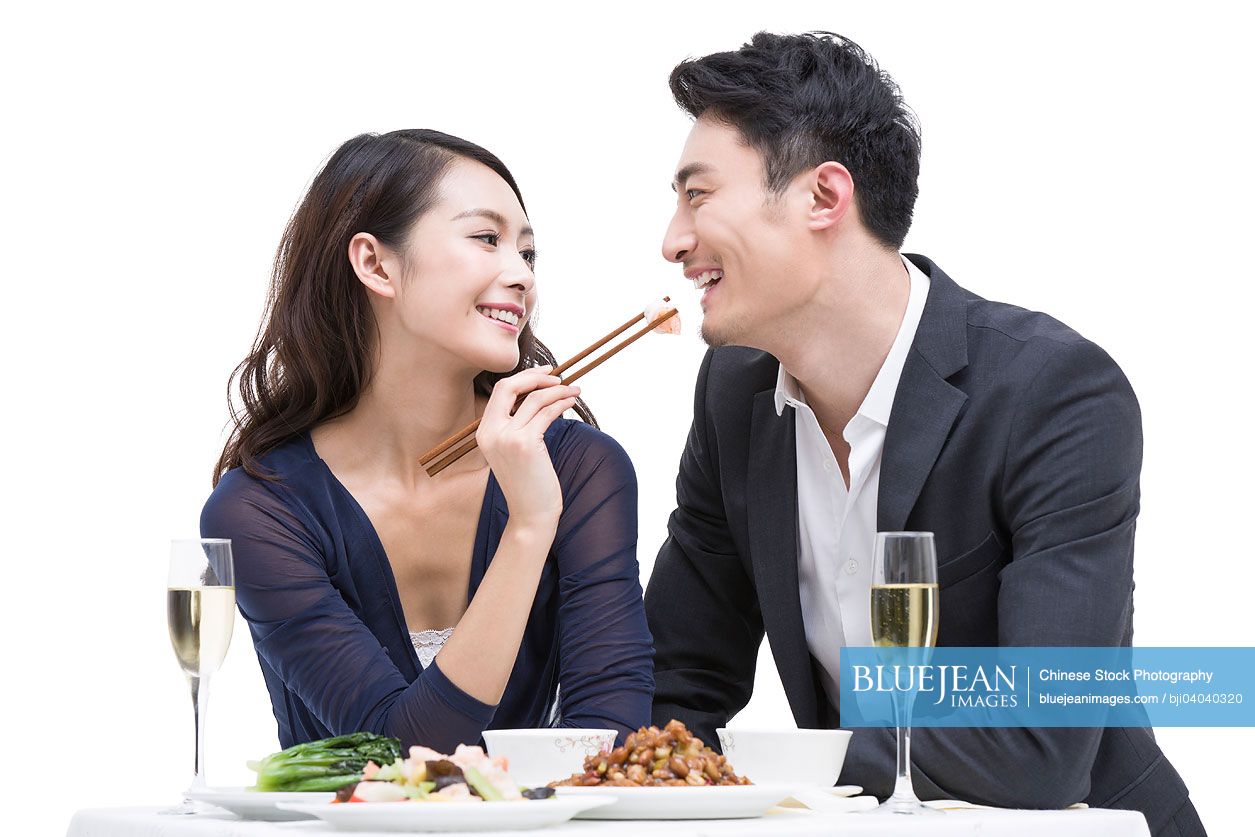 Happy young Chinese couple having dinner