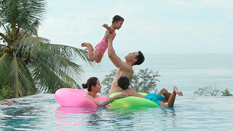 Happy young Chinese family having fun in swimming pool,4K