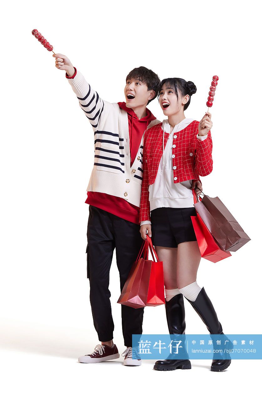 快乐的年轻情侣逛街购物吃冰糖葫芦