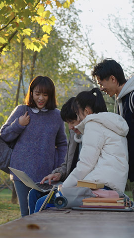 Happy Chinese college students using laptop and discussing,HD