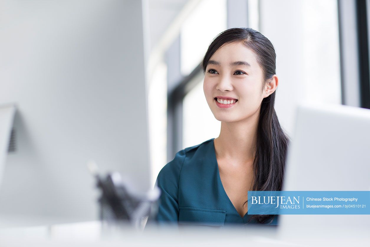Young Chinese businesswoman using computer in office