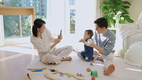 Young Chinese parents playing with their baby at home