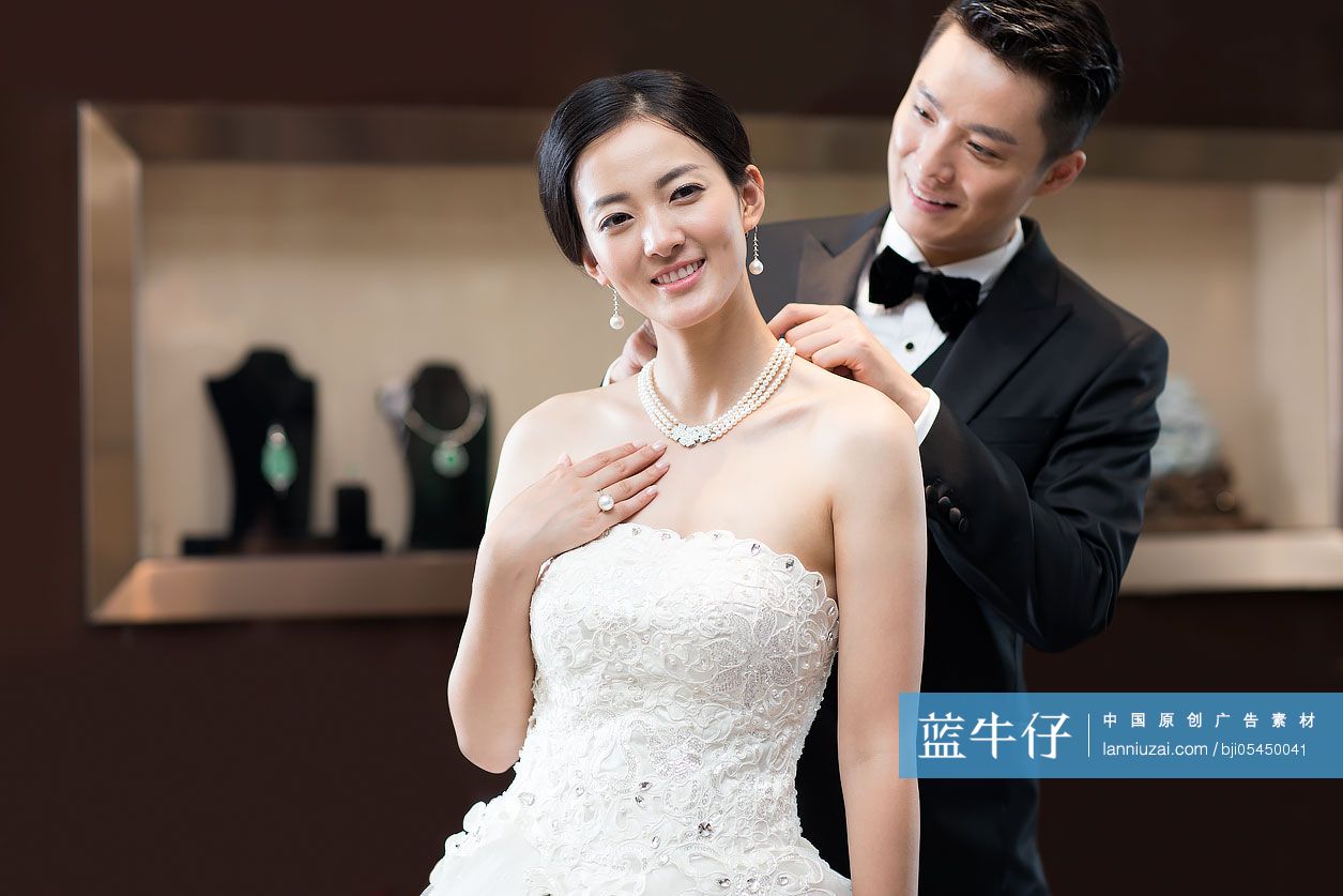 幸福的新郎为新娘戴珍珠项链