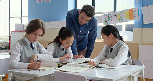 Young foreign teacher helping students in class,4K
