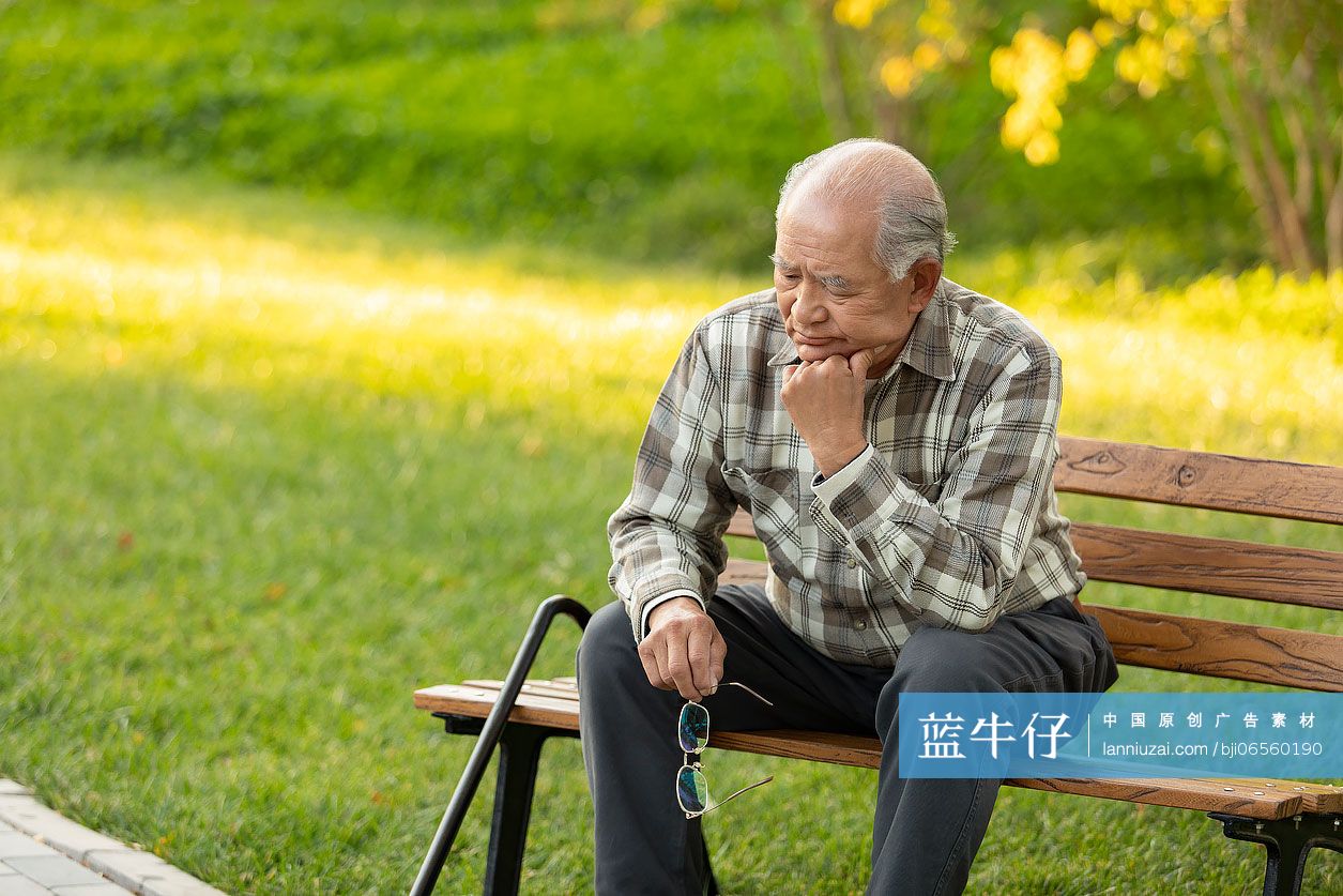 孤独的老人坐在公园长椅上