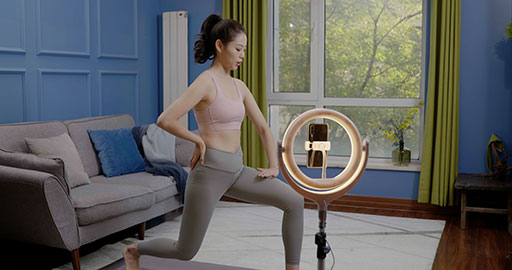 Female fitness influencer live-streaming a yoga session