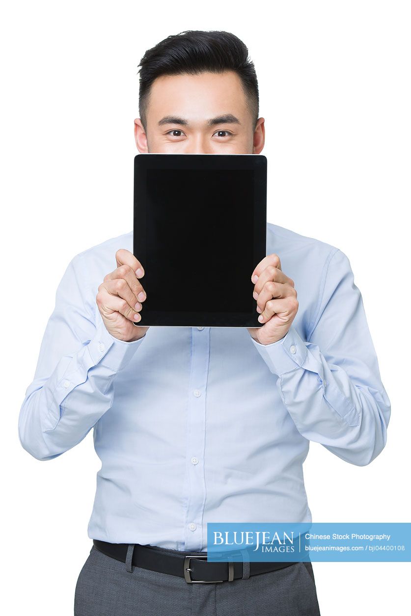 Young Chinese businessman holding a digital tablet