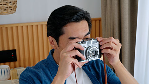 Chinese male photographer checking camera at home,4K