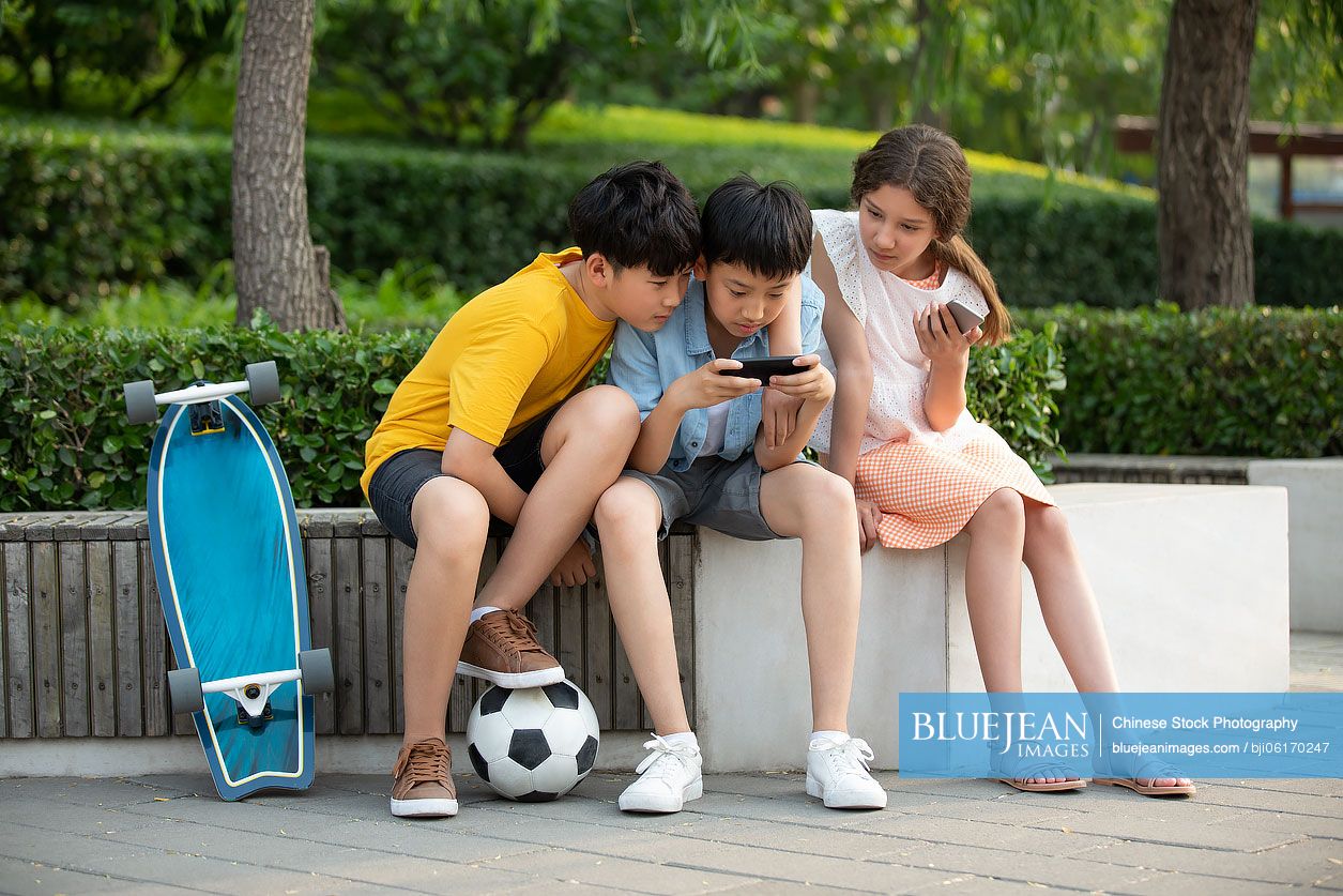 Teenagers using smartphone outdoors