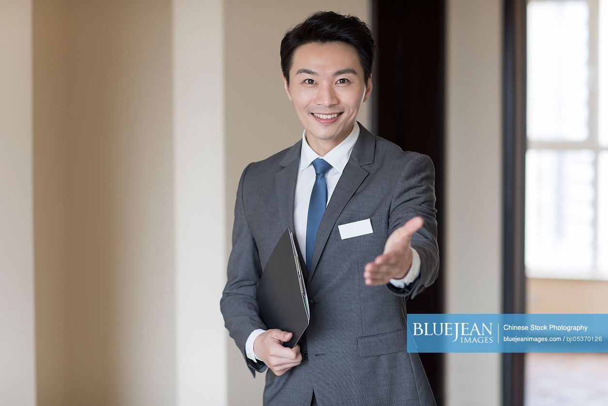 Confident Chinese male realtor greeting