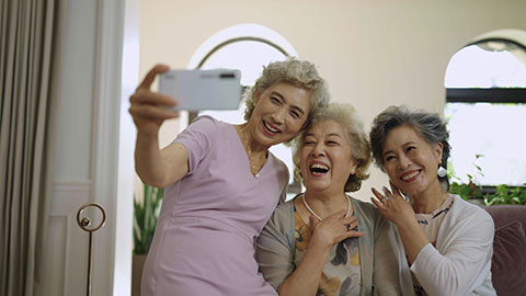 快乐的老年闺蜜使用手机自拍