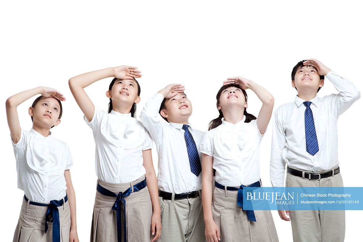 Chinese schoolchildren looking up with hands shielding eyes from the sun