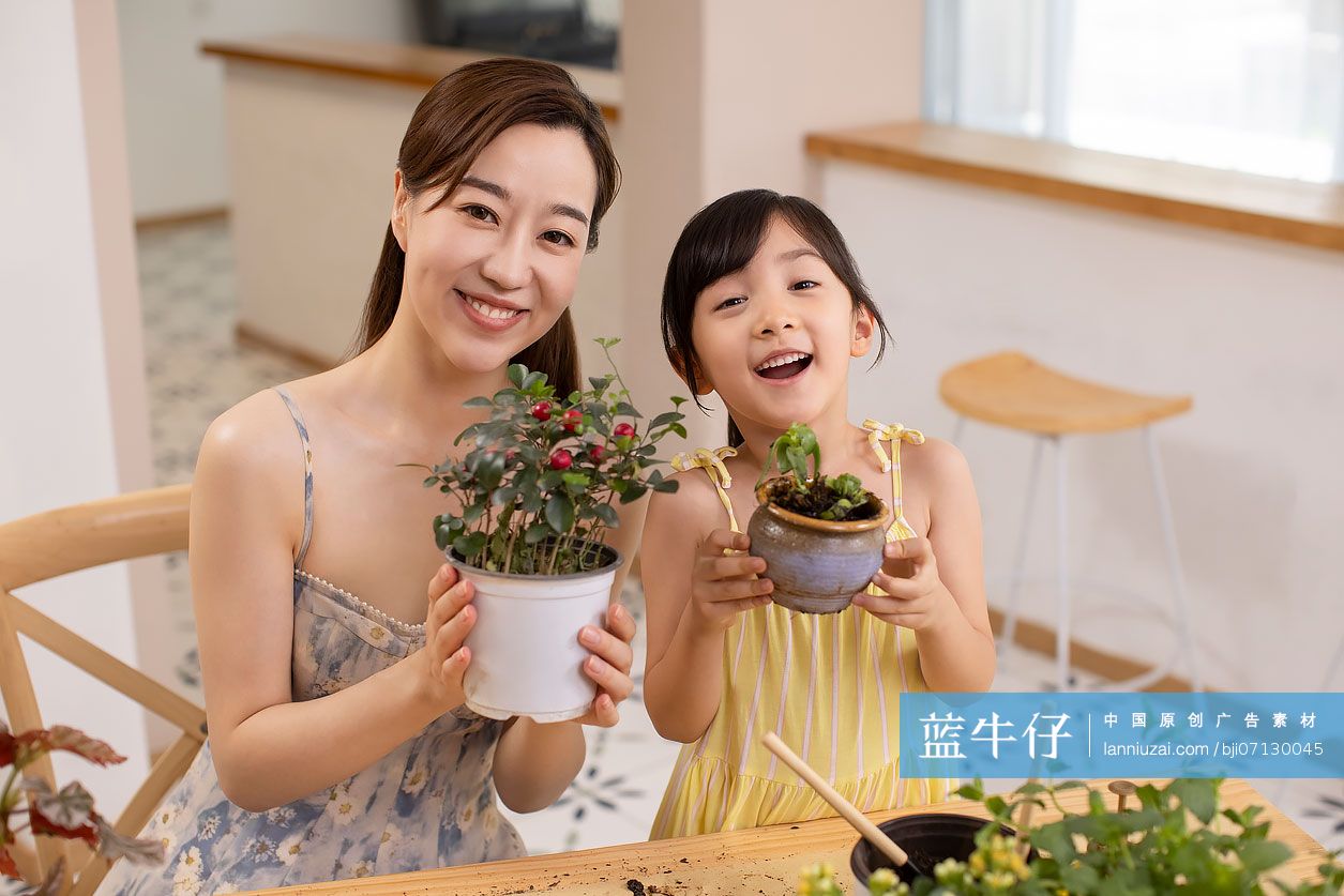 快乐的母女俩在家里种植盆栽