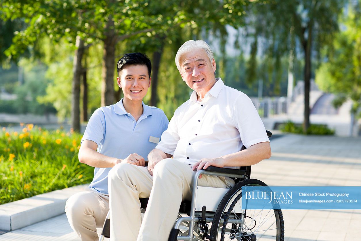 Wheelchair bound Chinese man with nursing assistant
