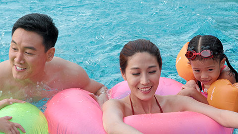 Happy young Chinese family having fun in swimming pool,4K