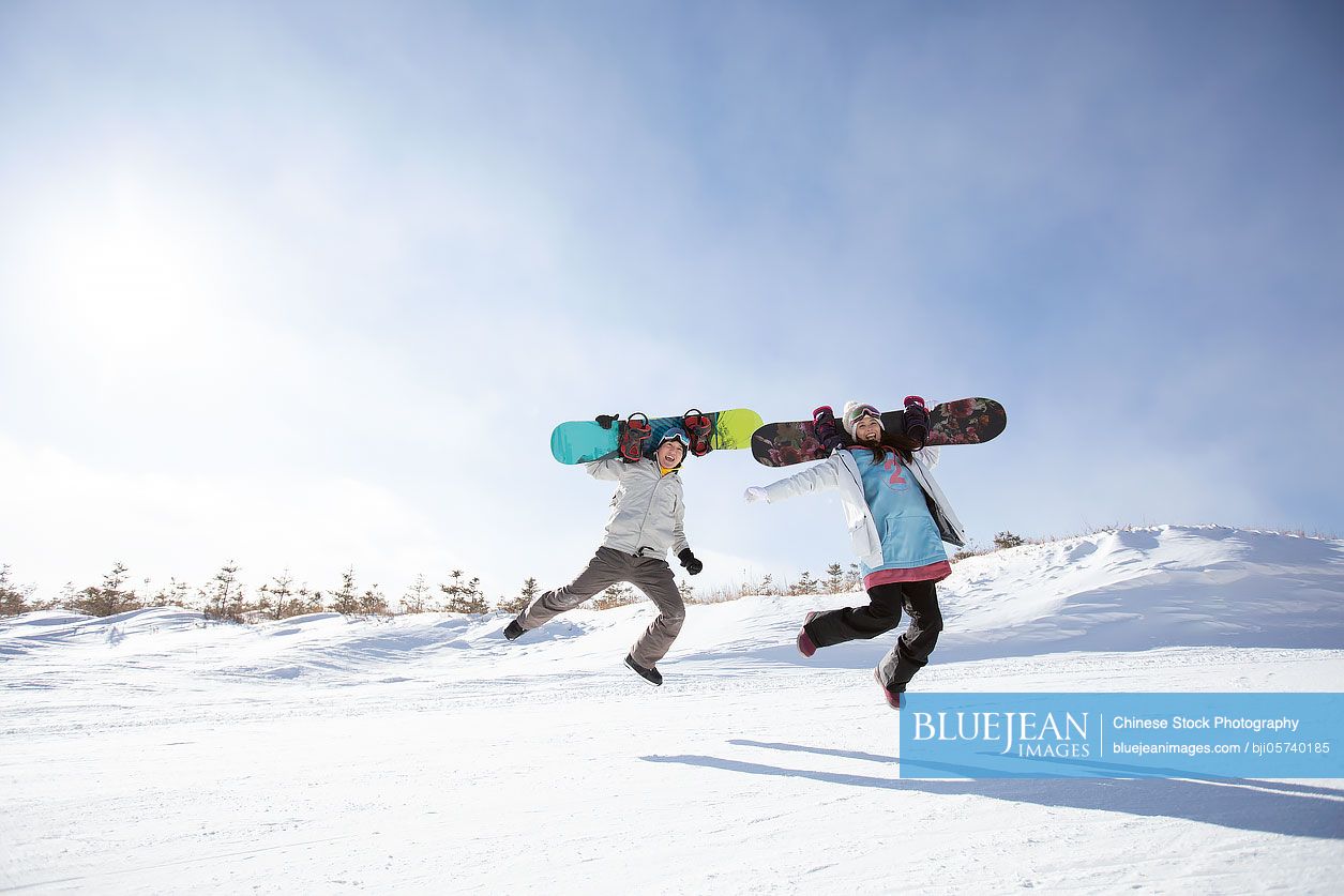 Happy young couple jumping in ski resort