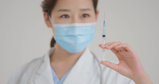 Young Chinese doctor holding syringe,4K