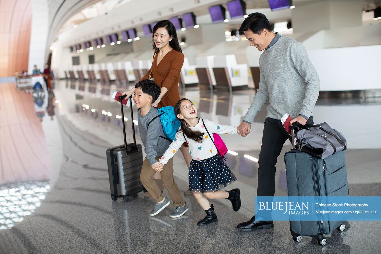 Happy young Chinese family travelling from airport