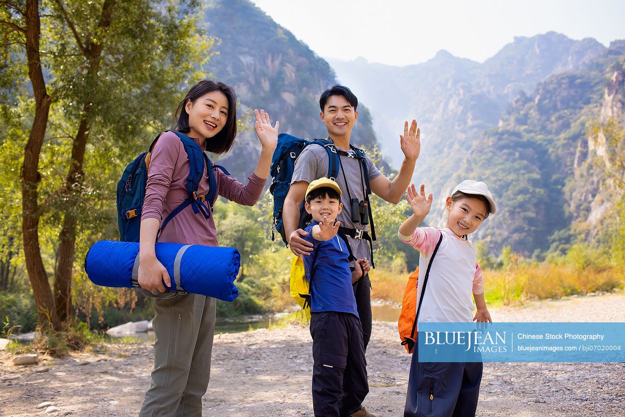 Happy young Chinese family hiking outdoors