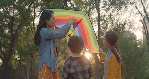 Happy young Chinese family flying a kite in park,4K