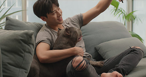 Young Chinese man playing with pet dog at home,4K