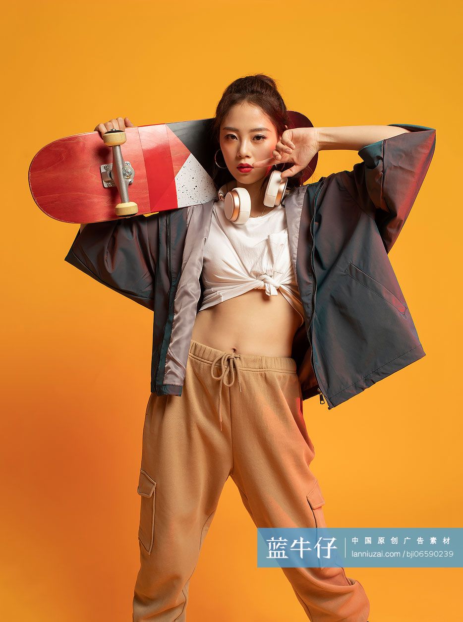 时尚的年轻女孩拿着滑板