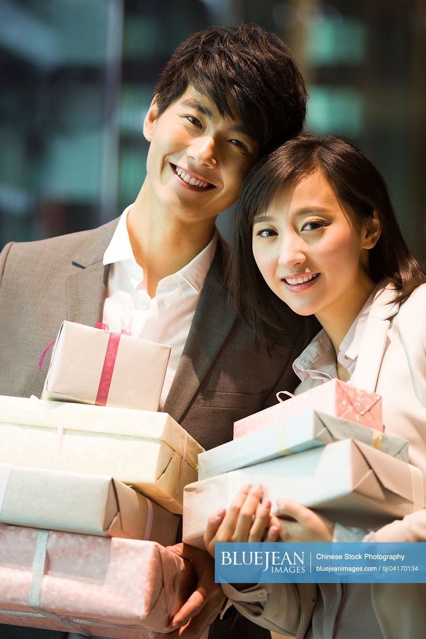 Happy young Chinese couple with gifts