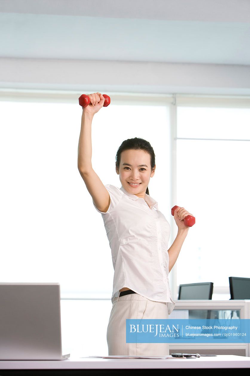 Chinese office worker working out in the office