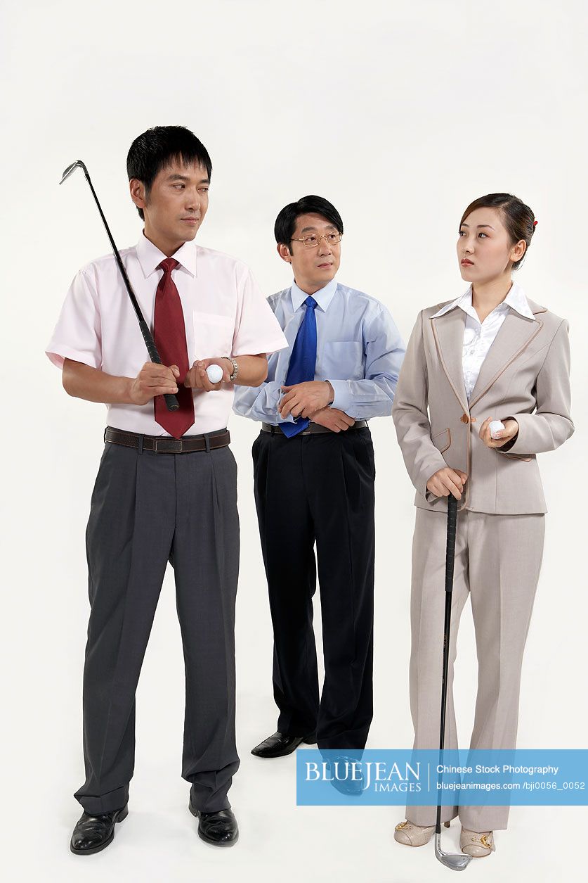 Chinese businessmen and businesswoman holding golf clubs