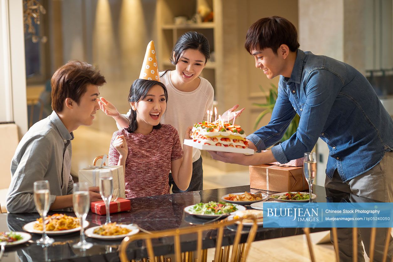 Young Chinese friends having birthday party at home
