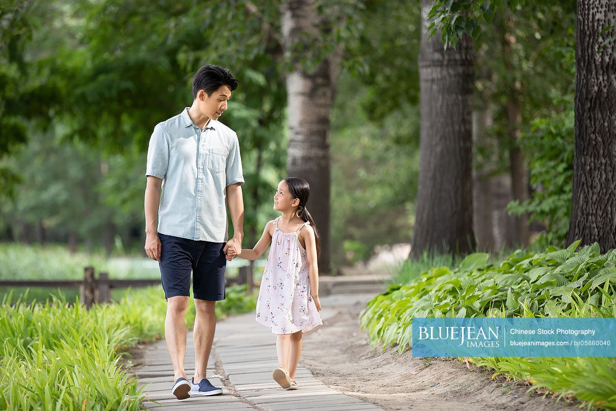 Happy Chinese father and daughter walking in park-High-res stock photo ...