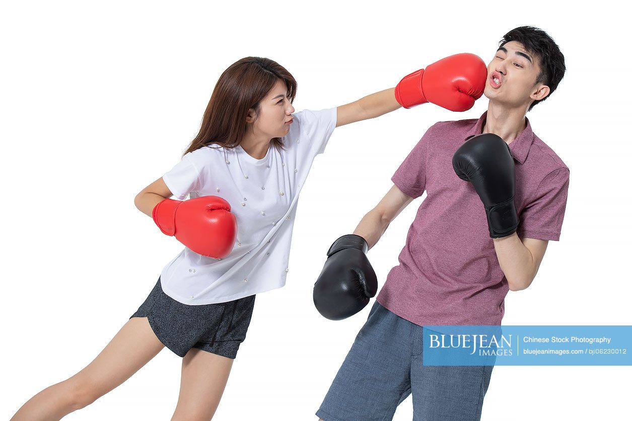 Humorous young Chinese couple practicing boxing