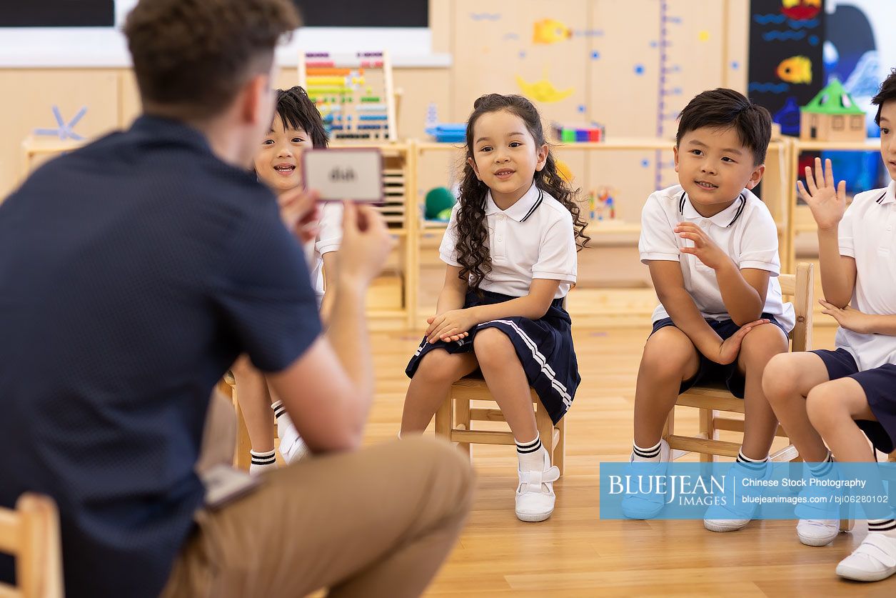 Foreign teacher teaching children English in classroom