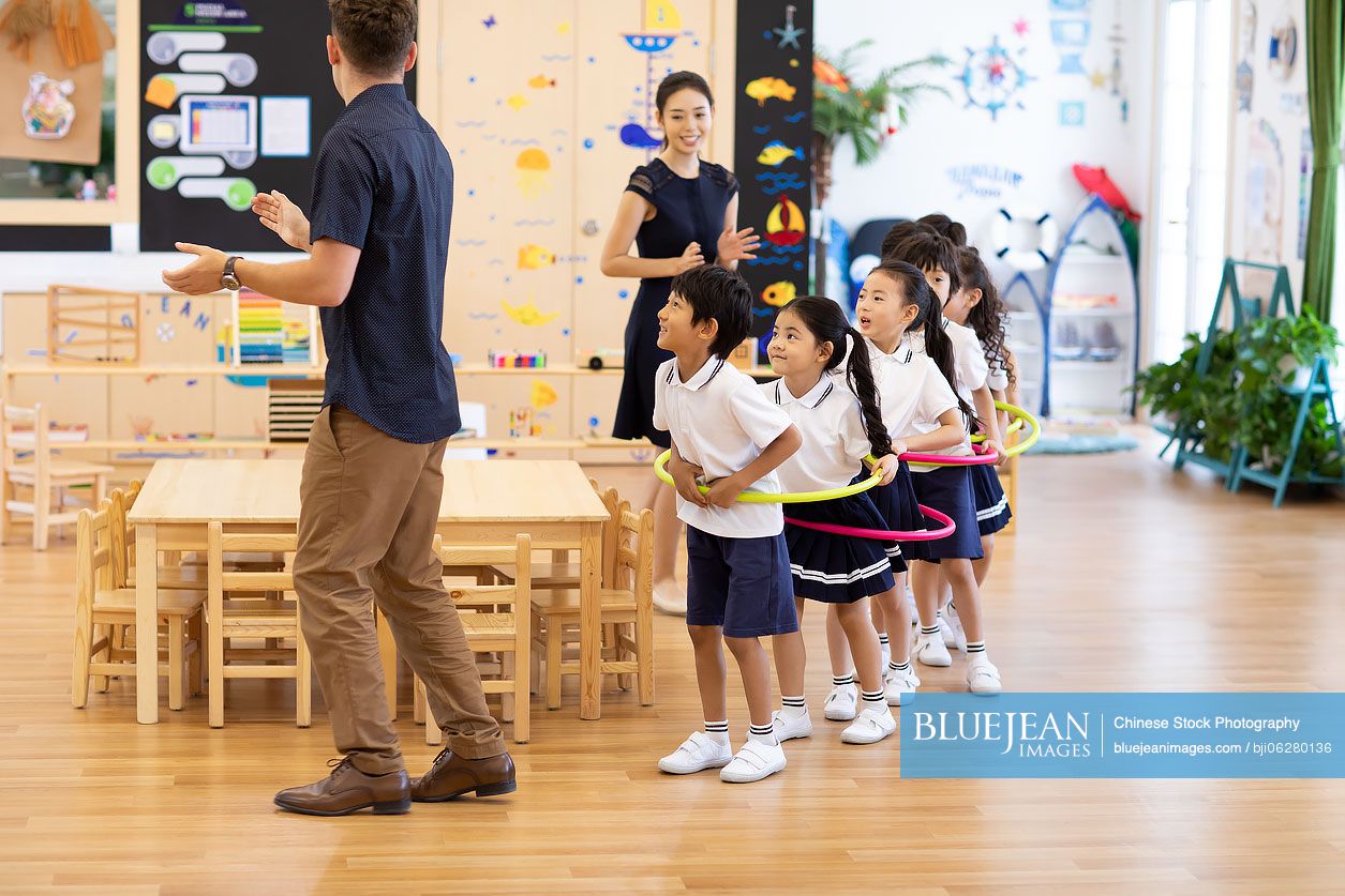 Teachers and children playing games in classroom