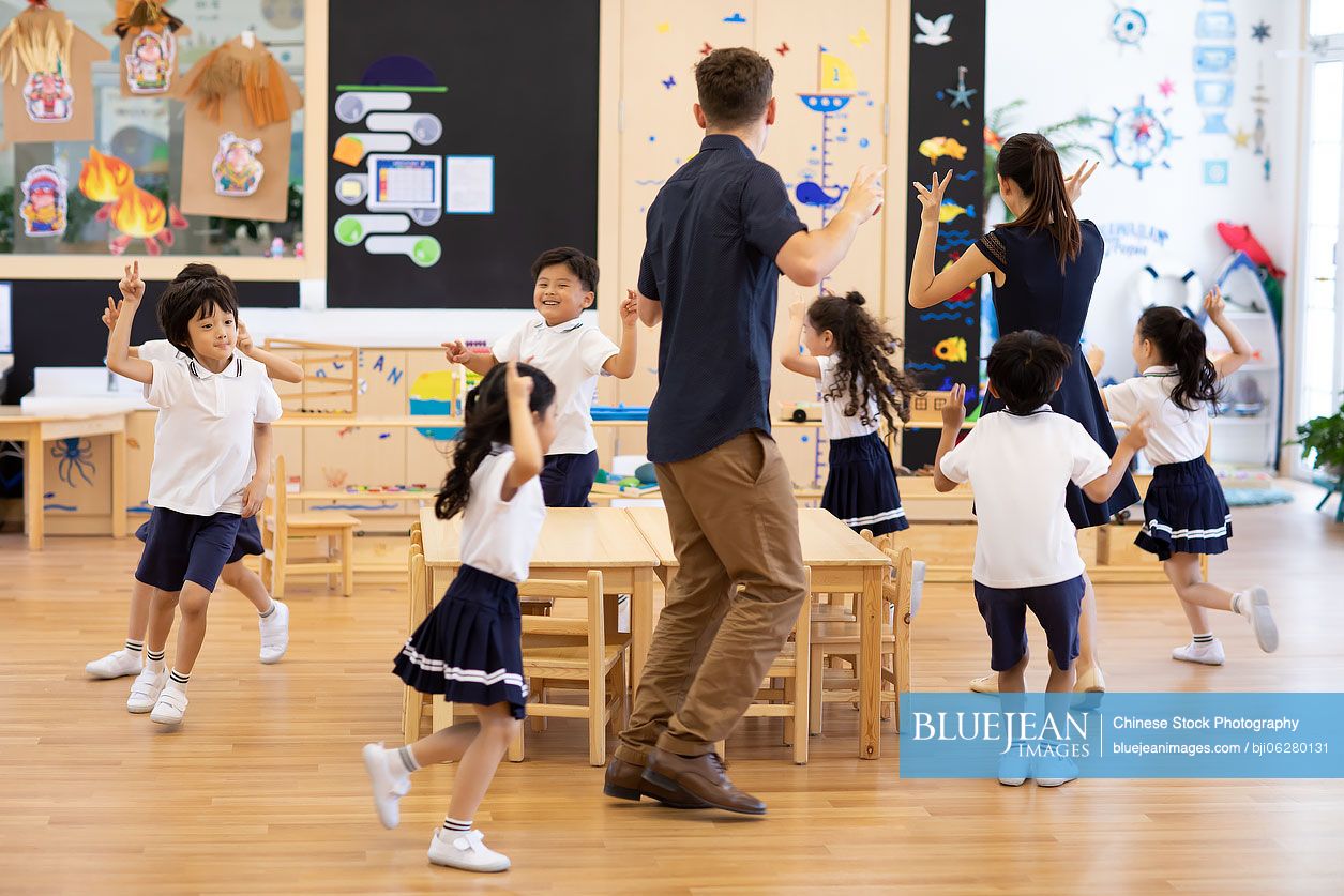 Teachers and children playing games in classroom