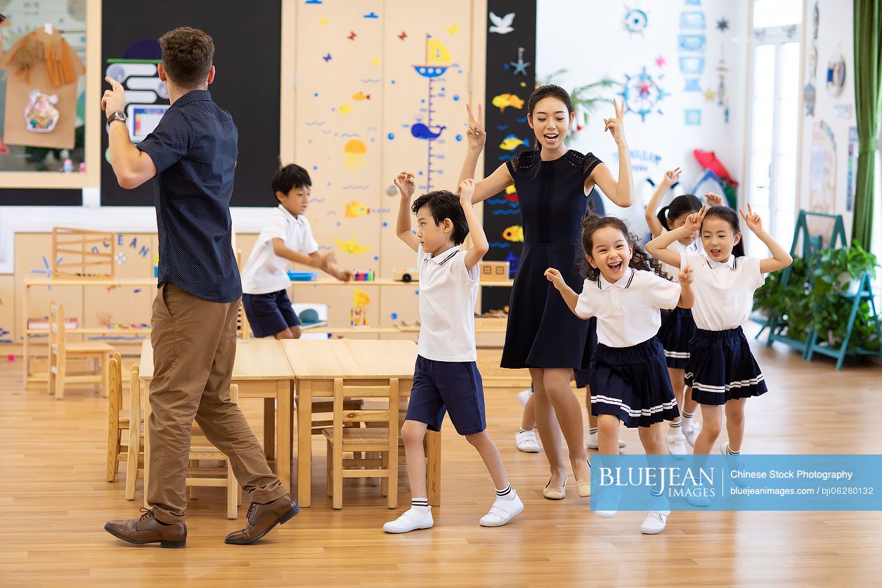 Teachers and children playing games in classroom