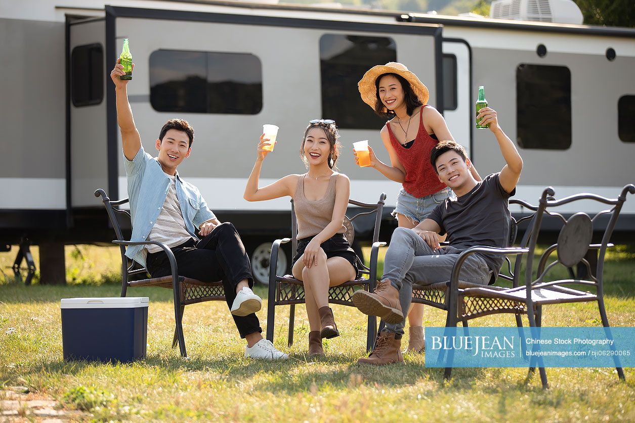 Happy young Chinese friends having a picnic outdoors