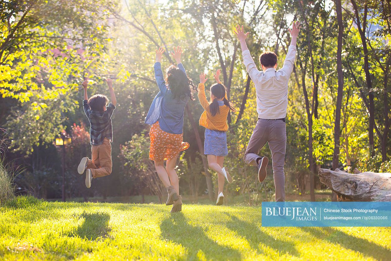 Happy young Chinese family having fun in park