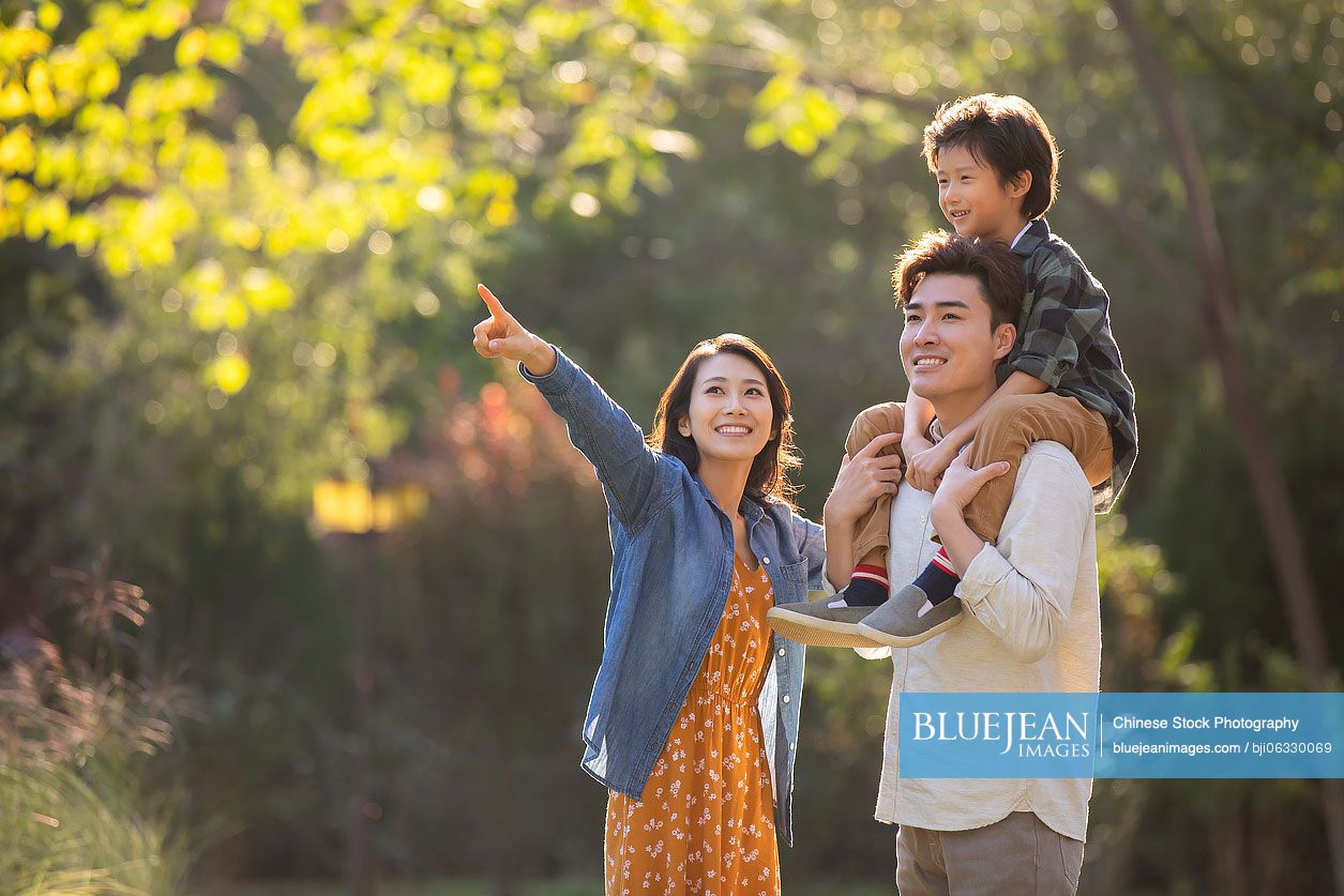 Happy young Chinese family having fun in park