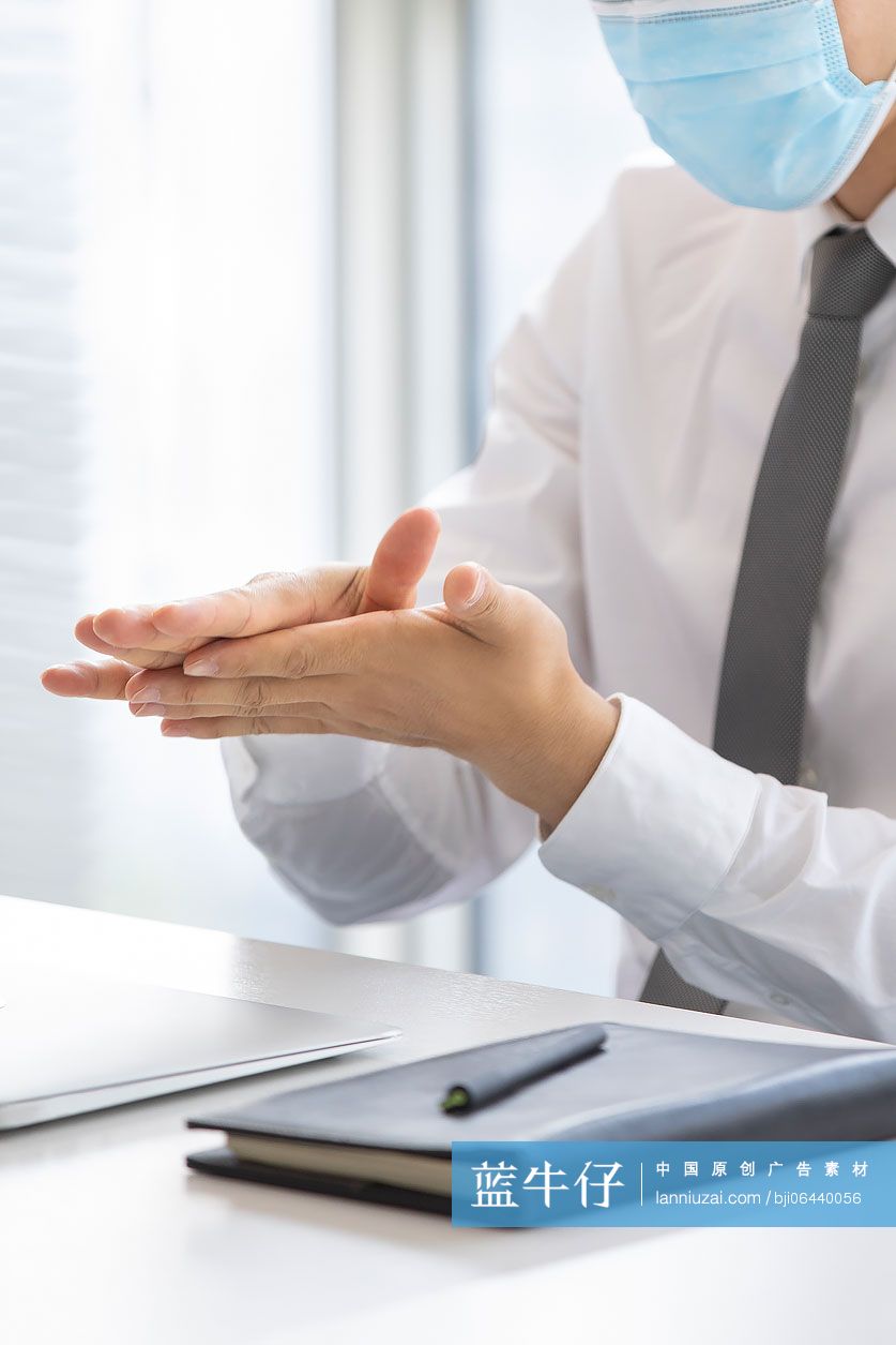 年轻的商务男士在办公室使用免洗洗手液