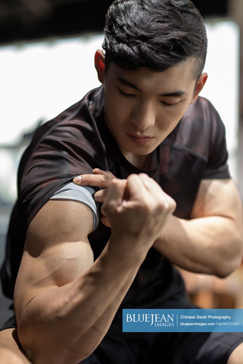 Young Chinese man exercising at gym