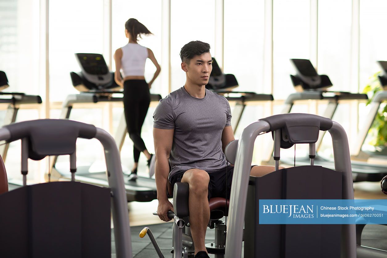 Young Chinese man exercising at gym