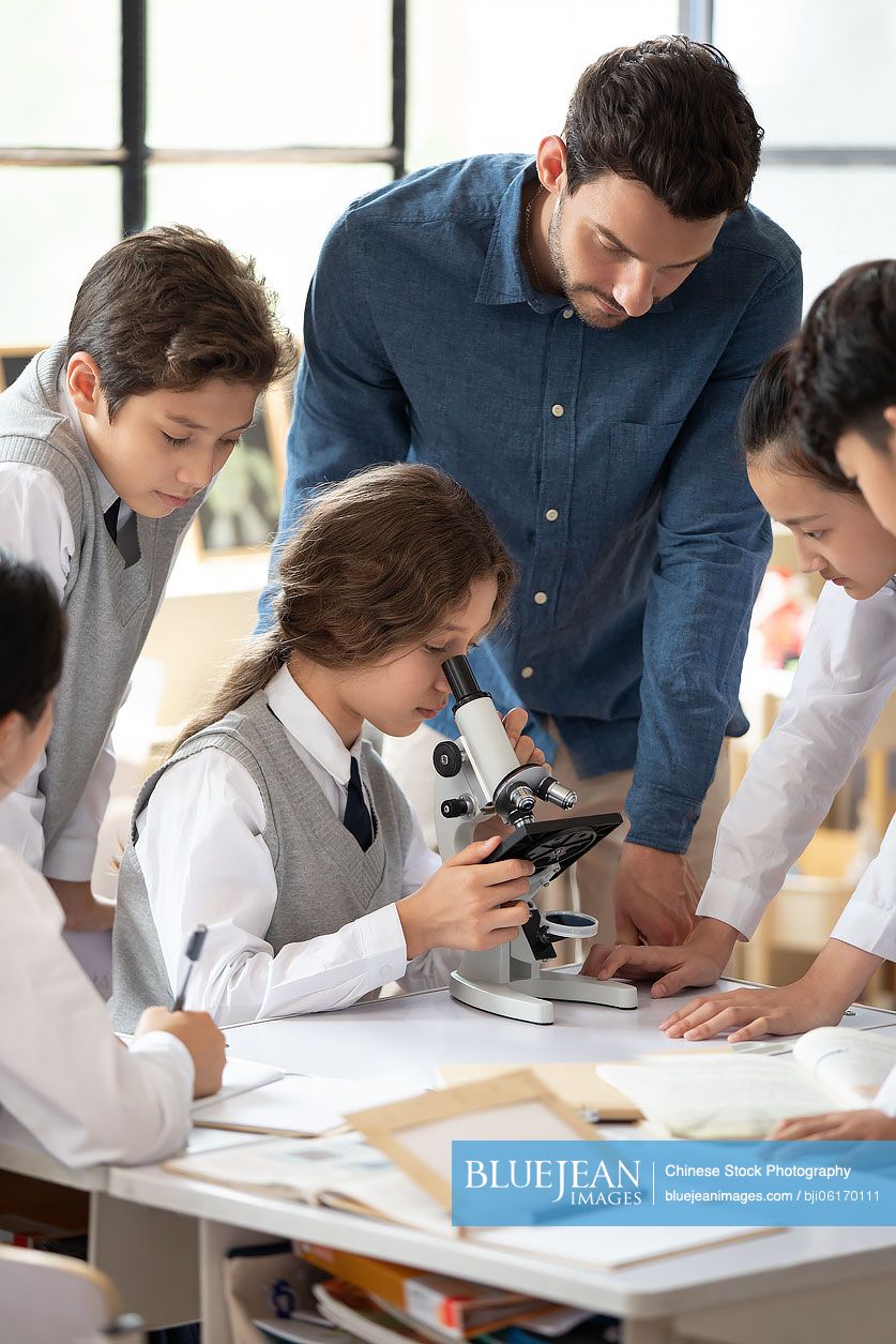 Students using microscope in classroom