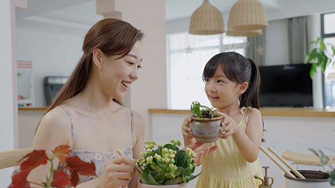 Mum and daughter enjoy potting plants together at home