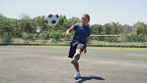 Happy Chinese man playing football