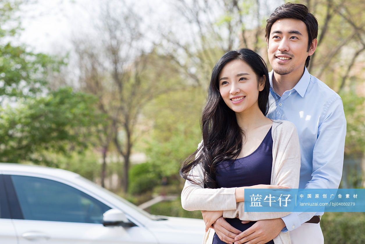 快乐的年轻夫妇和汽车