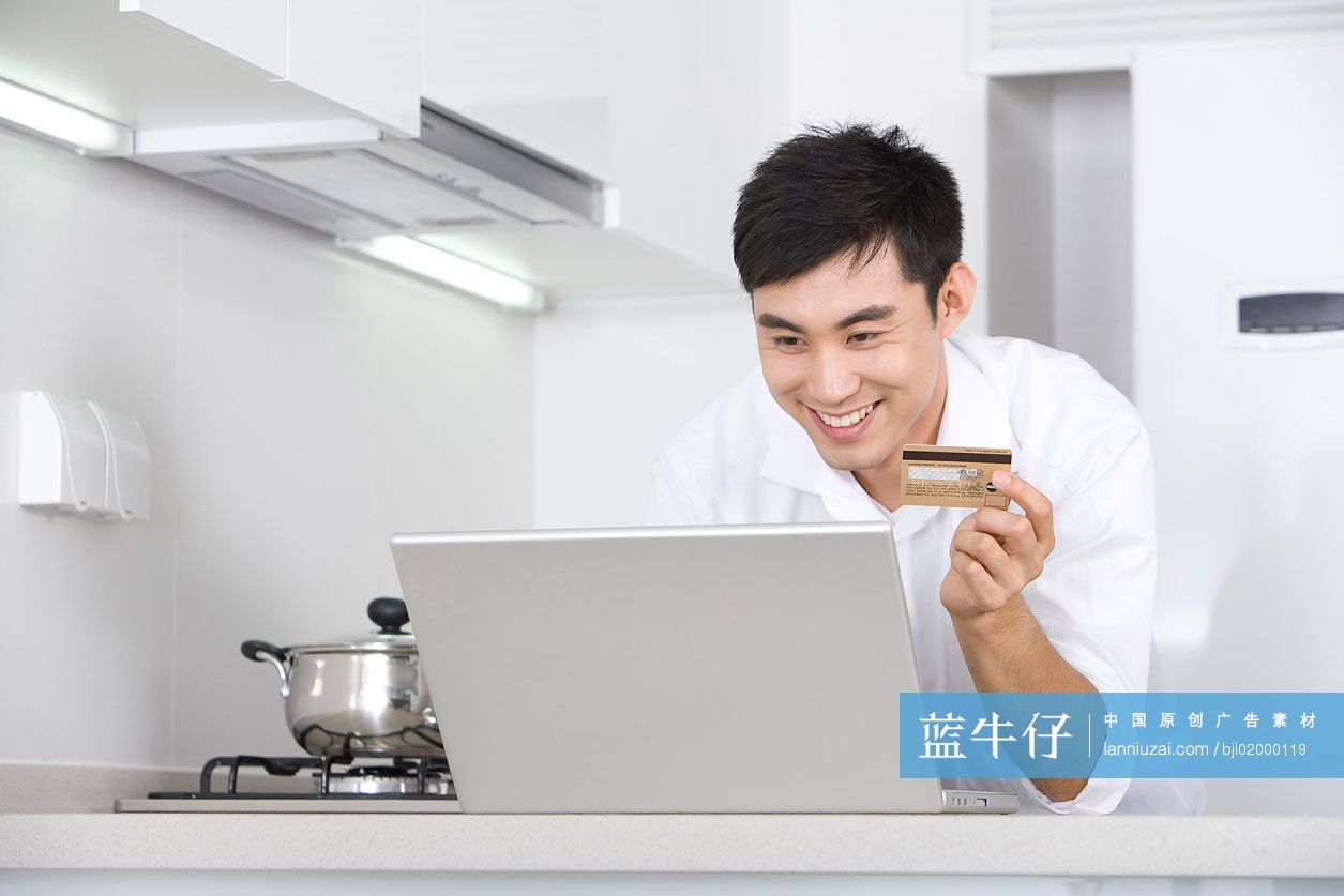 青年男子在厨房上网购物