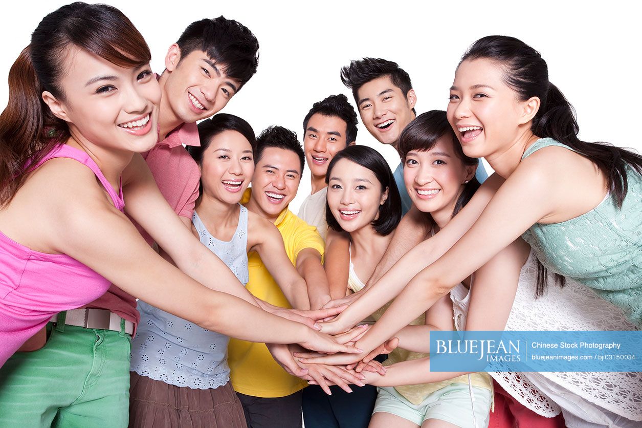 Group of young Chinese putting hands together